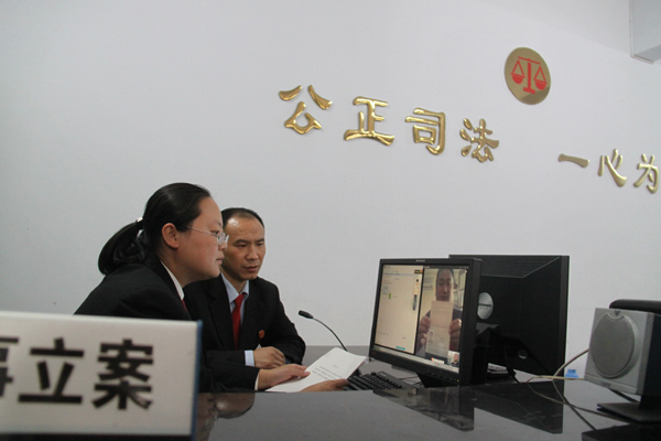 图为 该院法官通过QQ视频查看原告王建民的护照。.jpg